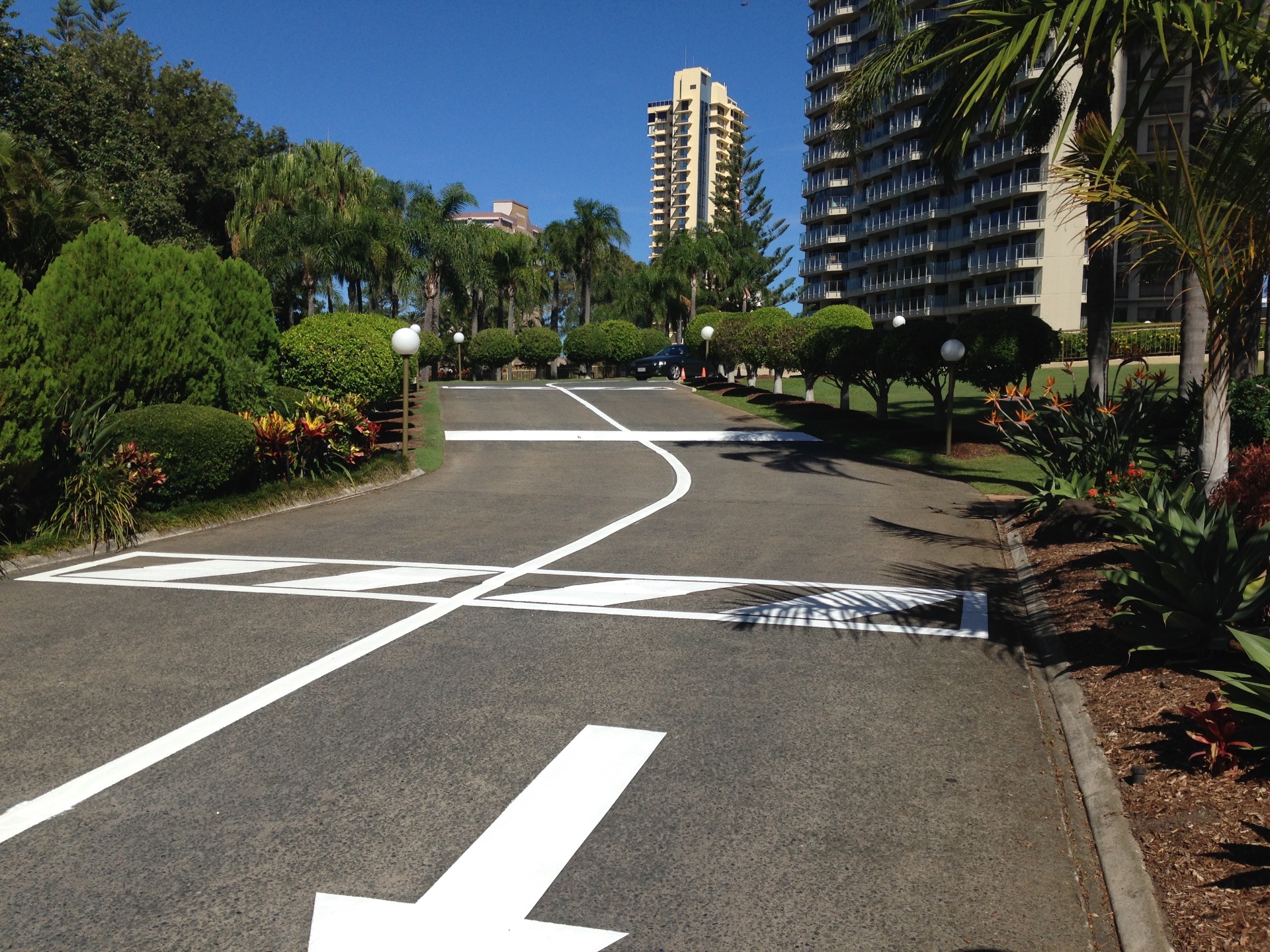 White directional arrows and give-way markings at residential complex entrance