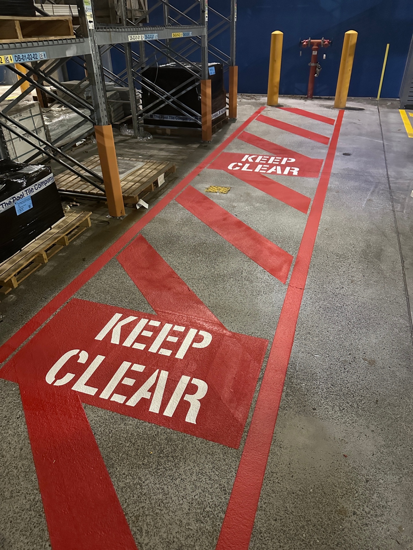 Red Keep Clear safety markings with hatched fire hydrant zone in warehouse