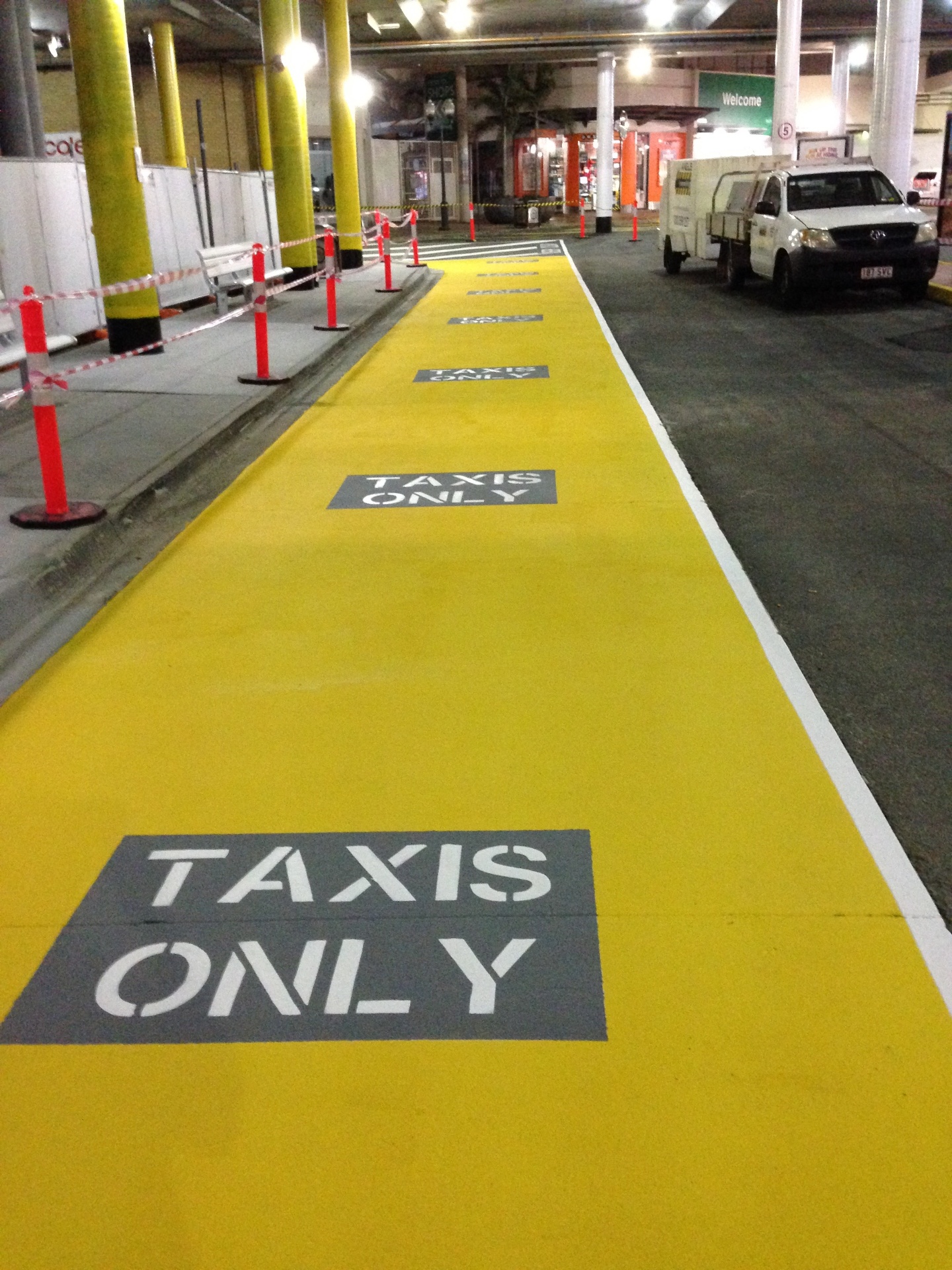 Yellow taxi lane with TAXIS ONLY stencils at shopping centre