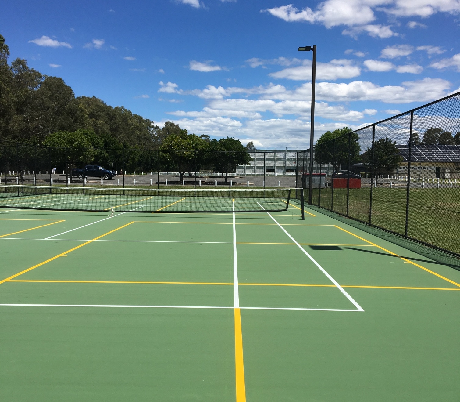 Multi-sport court with pickleball and tennis line marking in yellow and white