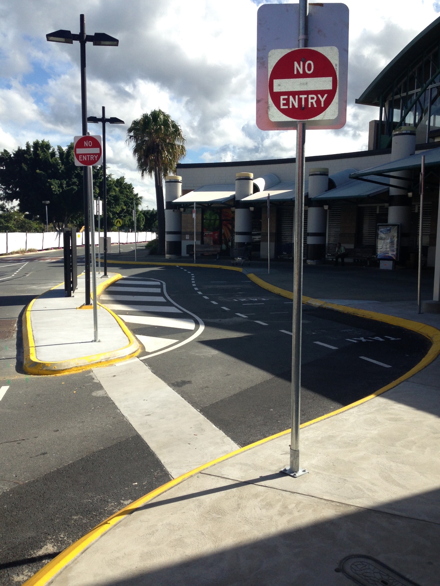No Entry signage installation with yellow kerb line marking at shopping centre