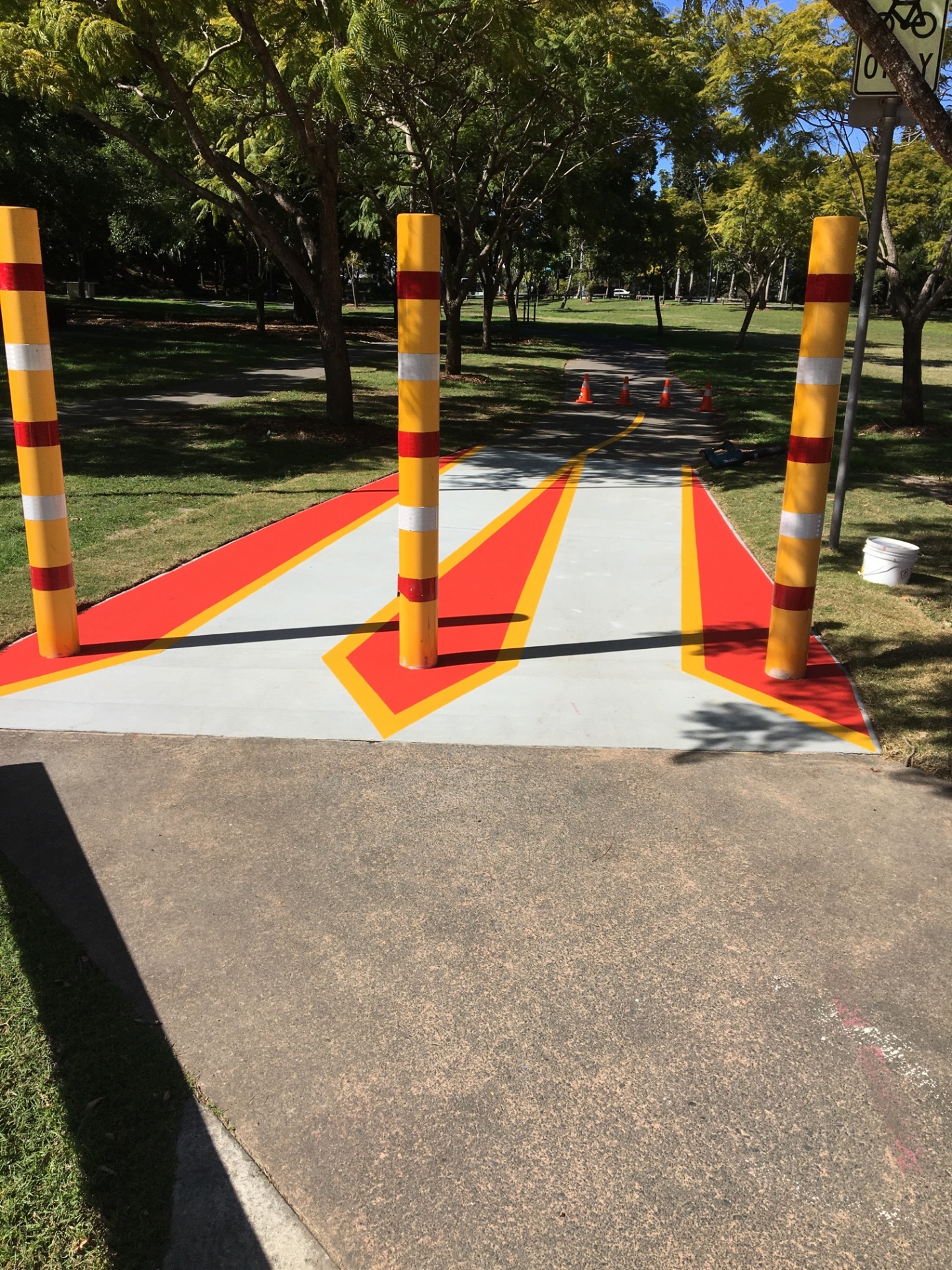 Yellow and red reflective bollards installed at park pathway entrance