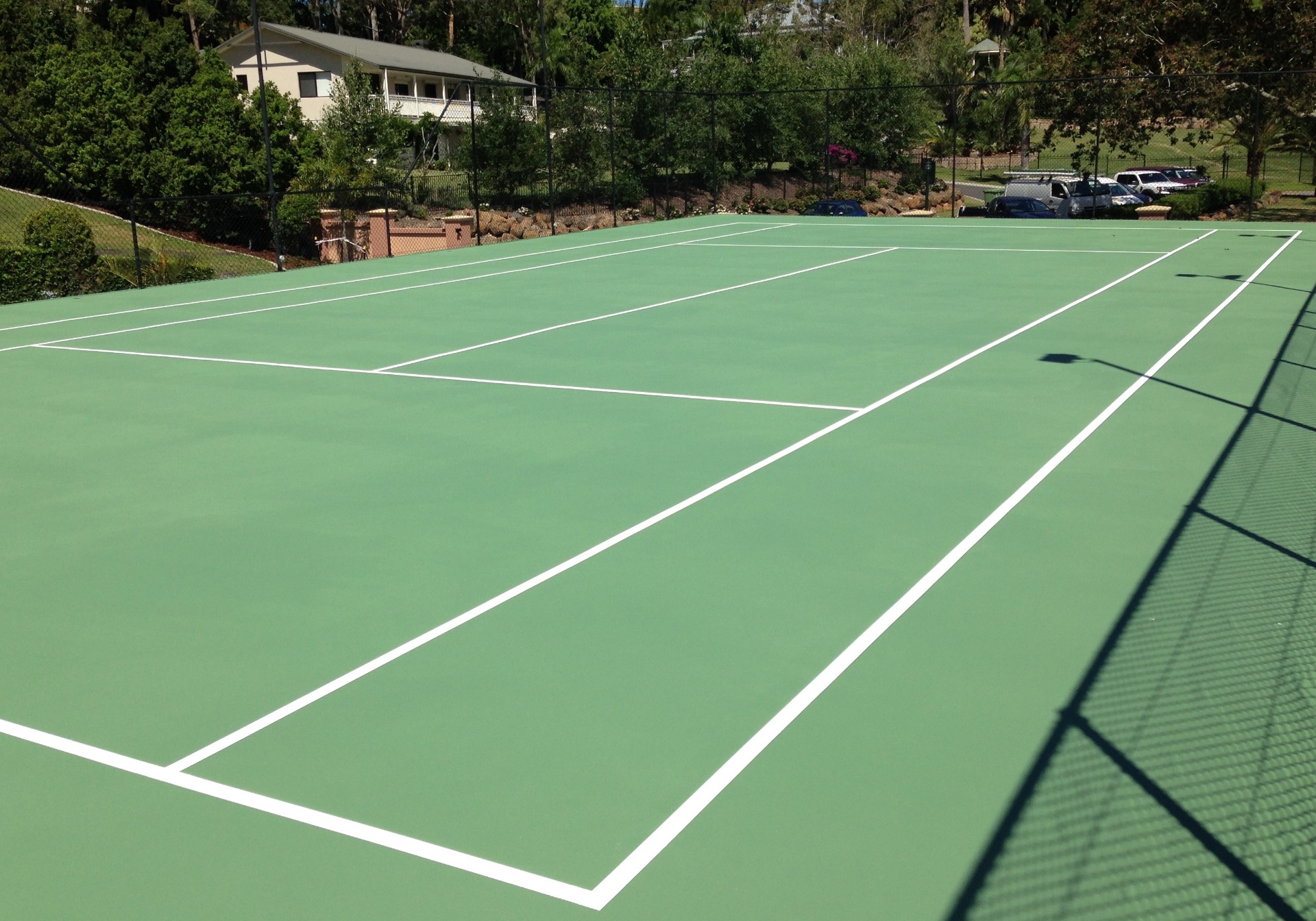 Freshly painted green tennis court with crisp white line marking