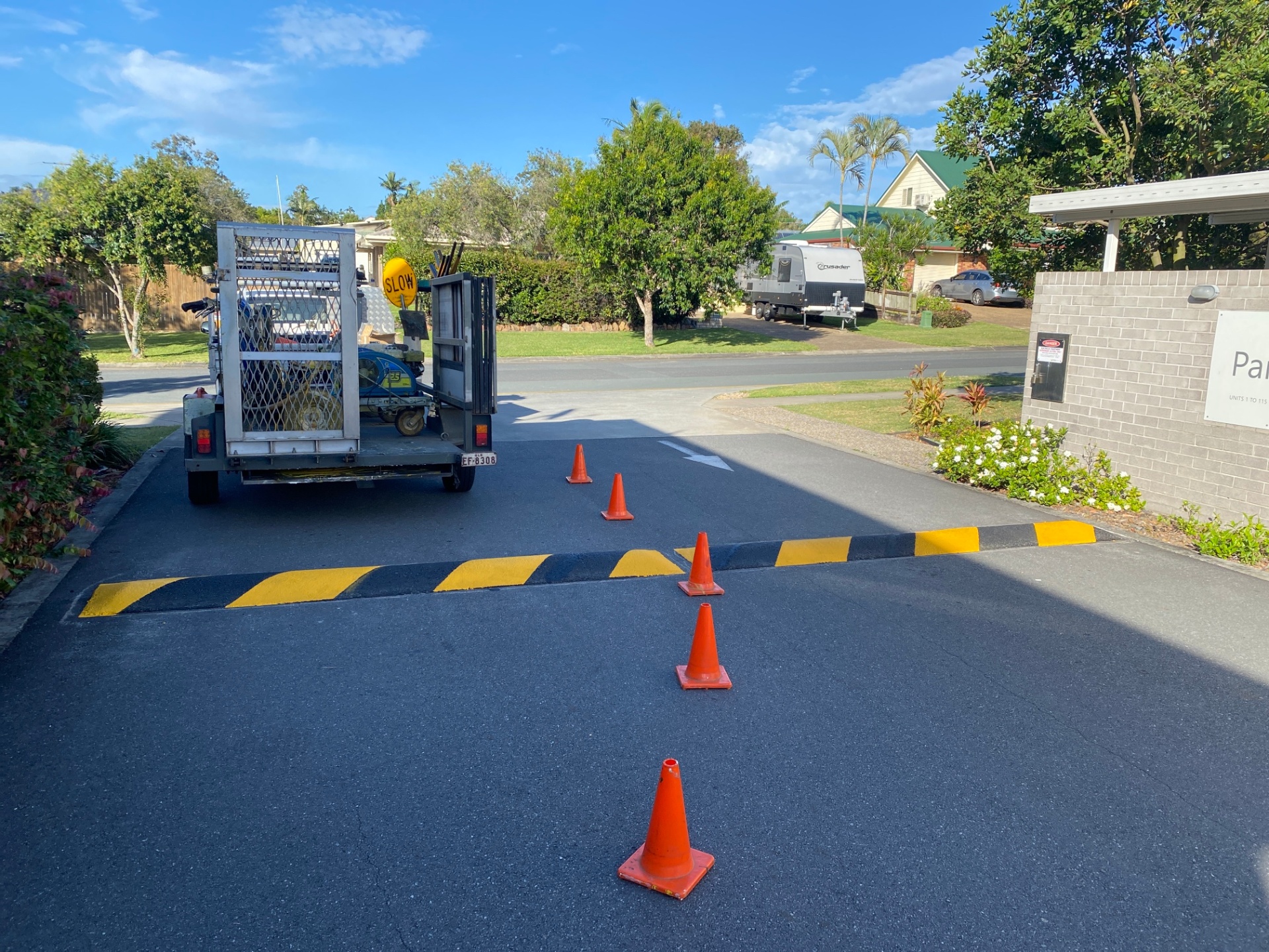 Yellow and black speed hump installation at residential complex driveway